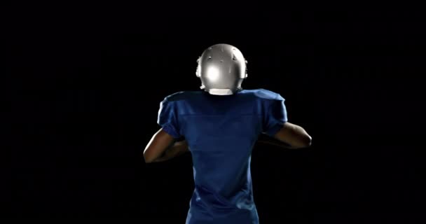 黒の背景にアメリカン フットボール プレーヤー — ストック動画
