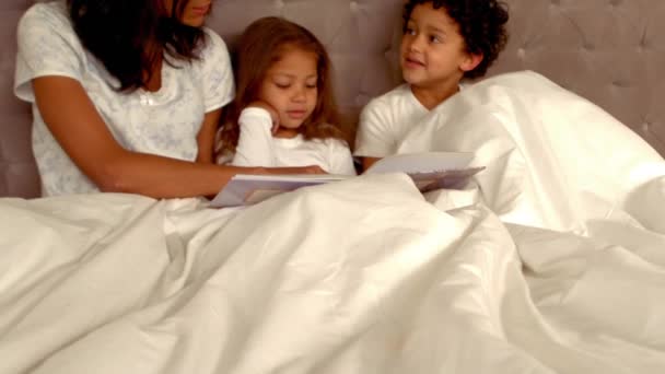 自宅のベッドで彼女の子供たちと笑顔のヒスパニック系母 — ストック動画