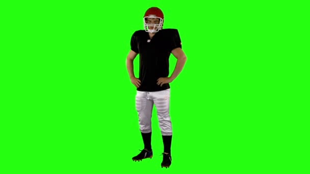緑の背景に腰に手をアメリカン フットボール プレーヤー — ストック動画