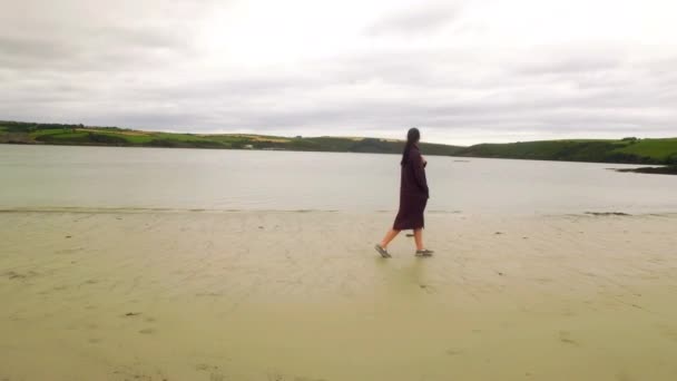 一位漂亮的女子 在沙滩上散步的侧视图 — 图库视频影像