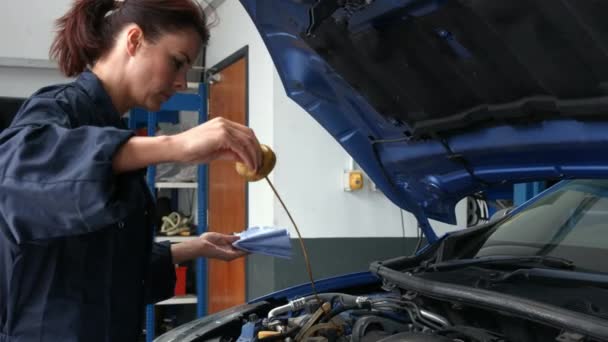女机械师检查在车库里发动机油 — 图库视频影像