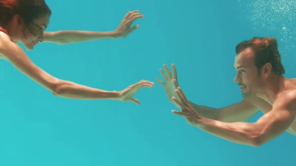 幸せなカップルがスローモーションで水中水泳 — ストック動画