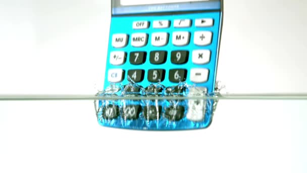 Голубой Калькулятор Падает Воду Белом Фоне — стоковое видео