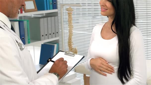 Doctor Escribiendo Hablando Con Mujer Embarazada Oficina — Vídeo de stock