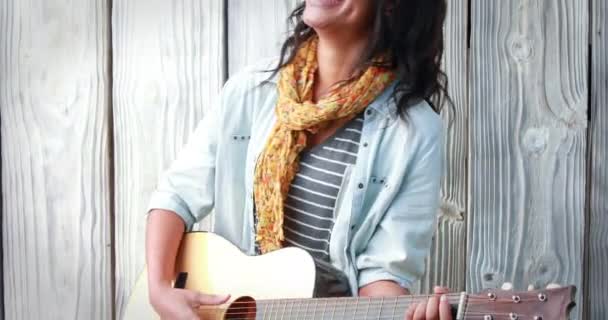 Gülümseyen Hipster Kadın Ahşap Arka Plan Üzerinde Gitar Çalmak — Stok video