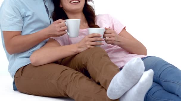Junges Paar Liegt Und Trinkt Kaffee Auf Weißem Hintergrund — Stockvideo