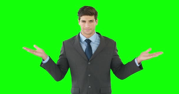 ビジネスマンの緑の背景に対して何かを提示 — ストック動画
