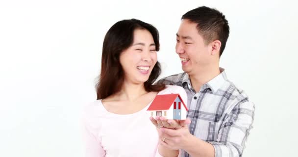 Pareja Feliz Sosteniendo Una Casita Sus Manos Pantalla Blanca — Vídeos de Stock