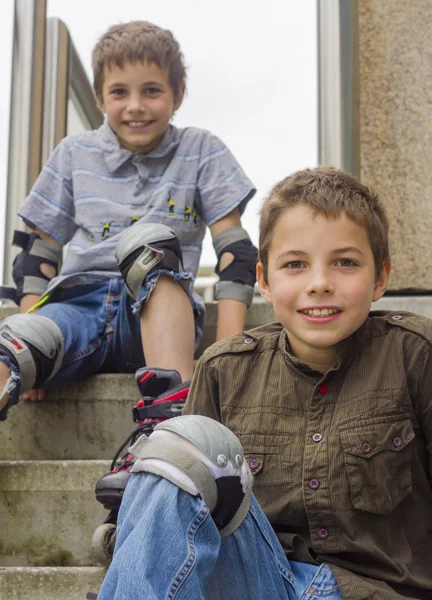 Δύο χαμογελώντας έφηβα αγόρια στην roller-blading Πρόχειρο φαρμακείο πρωσοπικής προστασίας Εικόνα Αρχείου