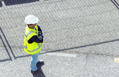 Standing worker on road works; horizontal orientation clipart