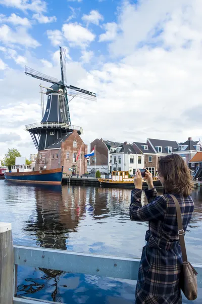 Turisztikai lány fotózni hagyományos holland szélmalom — Stock Fotó