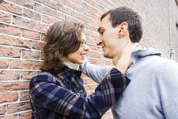 Portrait of love couple outdoor looking happy against wall backg — Stock Photo, Image