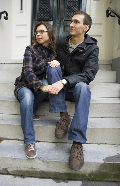 Portrait of love couple sitting on traditional Dutch porch looki — Stock Photo, Image