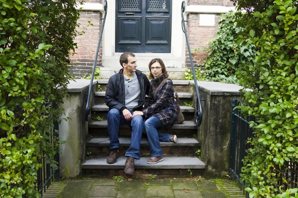 Retrato de pareja de amor sentado en el tradicional porche holandés mirando feliz —  Fotos de Stock