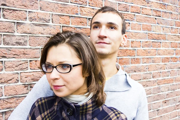 Portrait of love couple embracing looking happy against wall bac — Stock Photo, Image