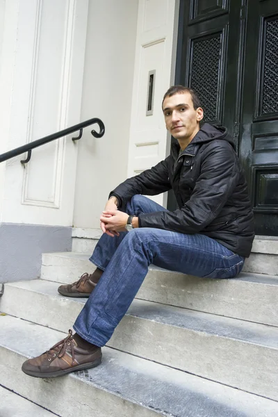 Portrait of young man sitting on traditional Dutch porch — Stock Photo, Image