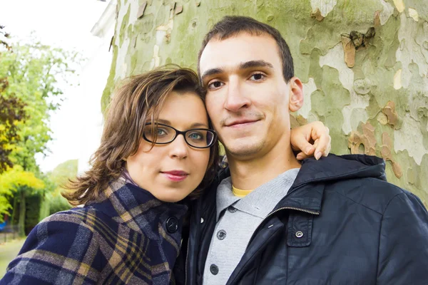 Portret van liefde paar omarmen buiten in park op zoek gelukkig — Stockfoto