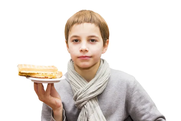 Portrait of a cute boy offering a waffle - isolated on white — Stock Photo, Image