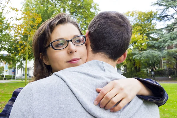 Retrato de casal de amor abraçando ao ar livre no parque olhando feliz — Fotografia de Stock