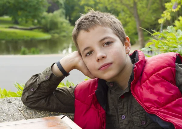 Söt tankeväckande tonårspojke mot grön bakgrund — Stockfoto