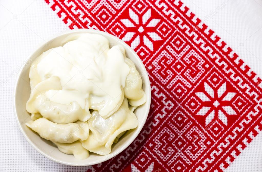 Dumplings with sour cream on the Ukrainian embroidered towel