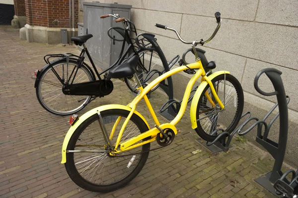 Yellow bike with flat tyre parked in a bicycle parking — Stockfoto