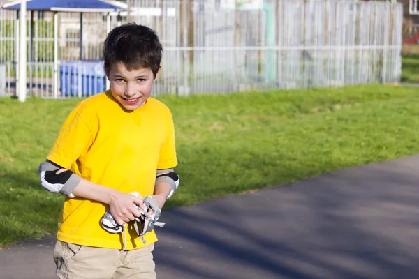 Der Junge zieht sich einen Rollenschutzsatz an — Stockfoto