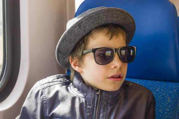 Beau garçon en lunettes de soleil promenades dans un train — Photo