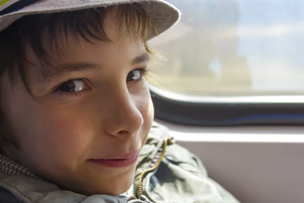 Bonito menino sorridente passeios em um trem — Fotografia de Stock