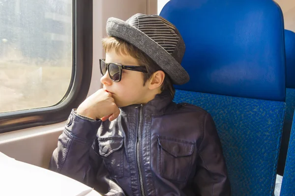 Beau garçon en lunettes de soleil promenades dans un train — Photo