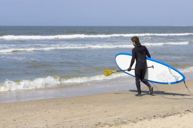 genç adam bir paddle kurulu denize girmeden Beach