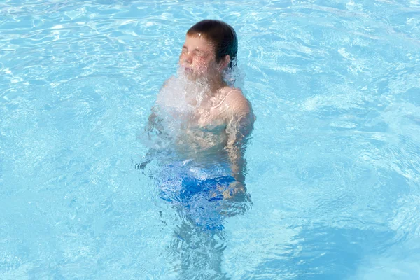 Actividades en la piscina. Lindo niño nadando y jugando en el agua i — Foto de Stock