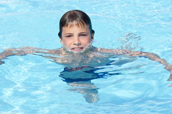 Actividades en la piscina. Lindo niño nadando y jugando en el agua i — Foto de Stock