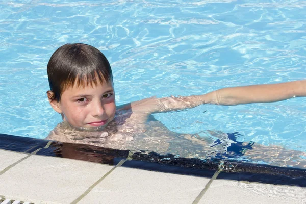 Actividades en la piscina. Lindo niño nadando y jugando en el agua i — Foto de Stock