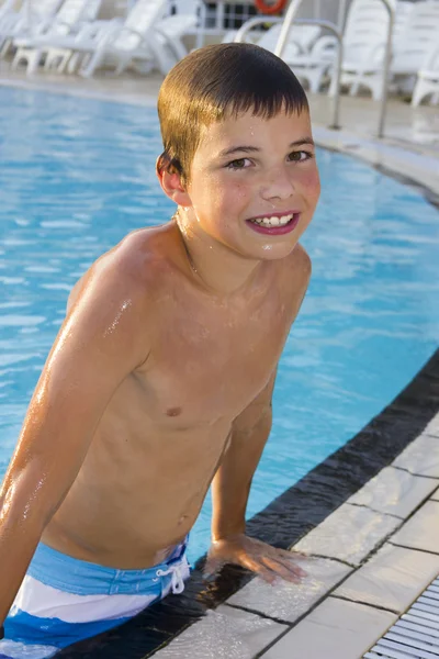 Actividades en la piscina. Lindo niño nadando y jugando en el agua i — Foto de Stock