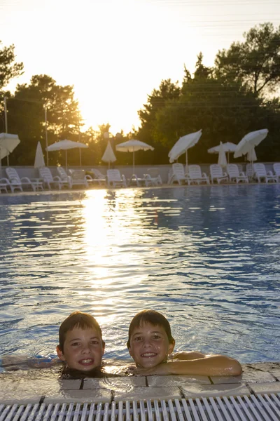 Actividades en la piscina. Lindos chicos nadando y jugando en el agua —  Fotos de Stock