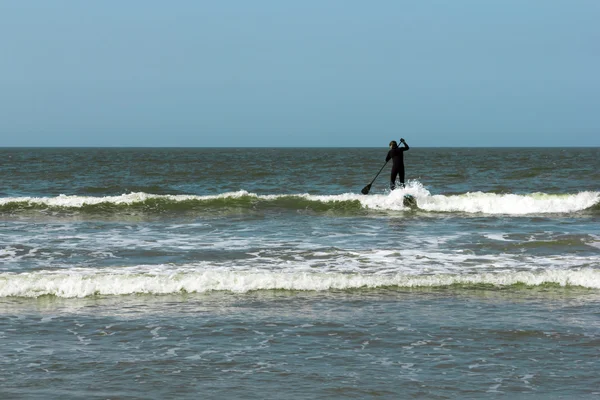 Joven en el mar sobre tabla de paddle — Foto de Stock