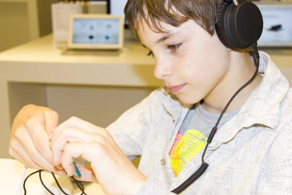 Porträtt av en söt ung pojke lyssna på musik i hörlurar — Stockfoto