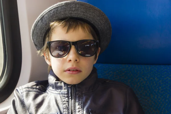 Stilig pojke i solglasögon rider på ett tåg — Stockfoto