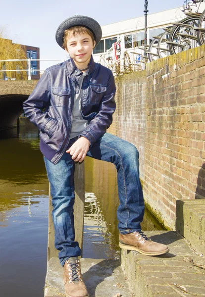 Симпатичный подросток в шляпе (полноразмерный портрет) против канала — стоковое фото