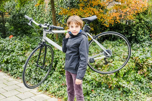 Young boy carrying his bike — Stock Photo, Image