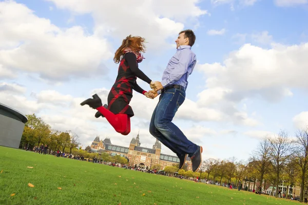 Outdoor coppia felice saltando in museumplein, amsterdam — Foto Stock