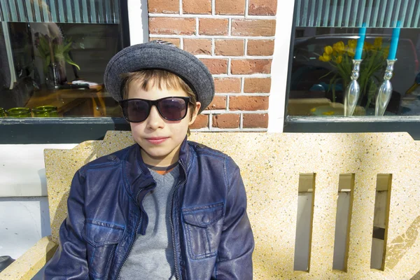 Niño con gafas sentado en un banco en frente de la casa, La N — Foto de Stock