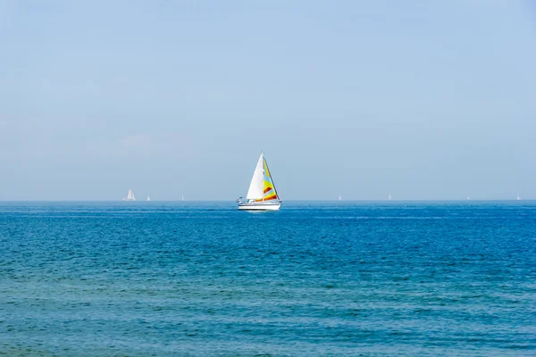 Zeegezicht met zeilboot de achtergrond van de blauwe hemel. — Stockfoto