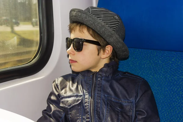 Knappe jongen in zonnebril rijdt op een trein — Stockfoto