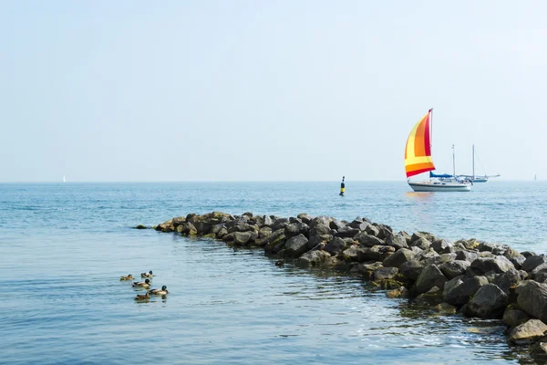 Zeegezicht met zeilboot de achtergrond van de blauwe hemel. — Stockfoto