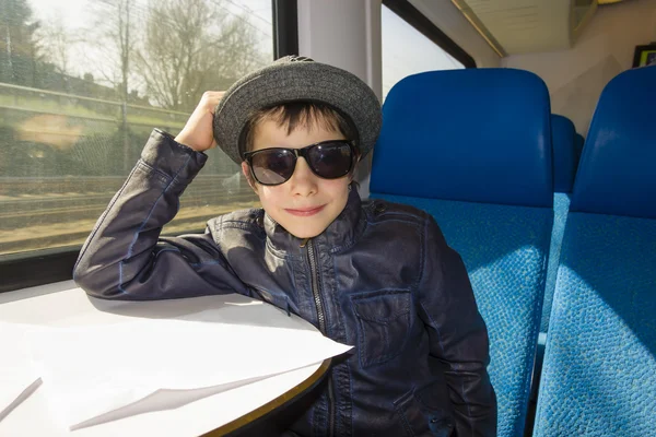 Menino bonito em óculos de sol passeios em um trem — Fotografia de Stock
