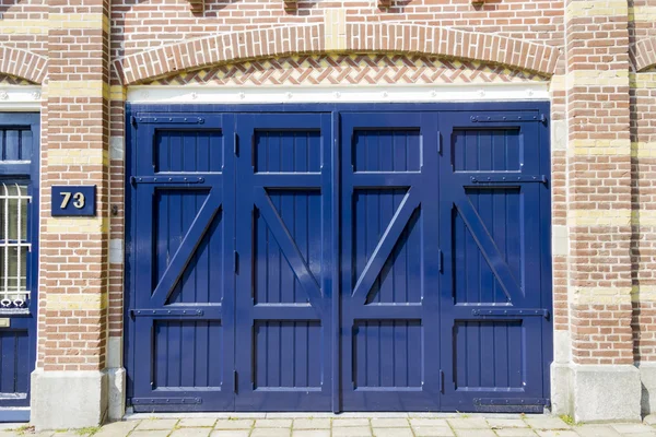 Fundo da porta de madeira azul antigo na casa número 73 — Fotografia de Stock