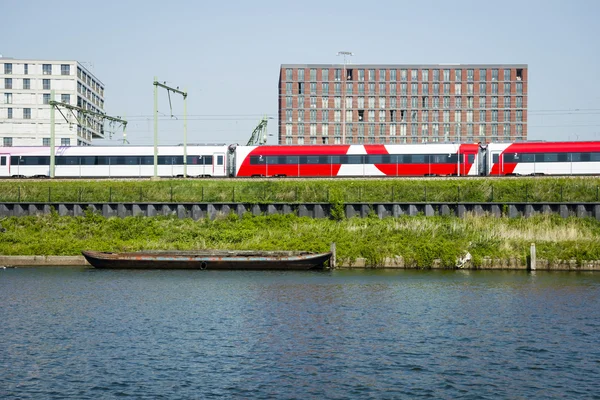 Cityscape of Amsterdam with train, canal, modern buildings and o — Stock Photo, Image