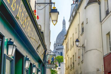 Street in Montmartre and Sacre Coeur Cathedral in Paris, France